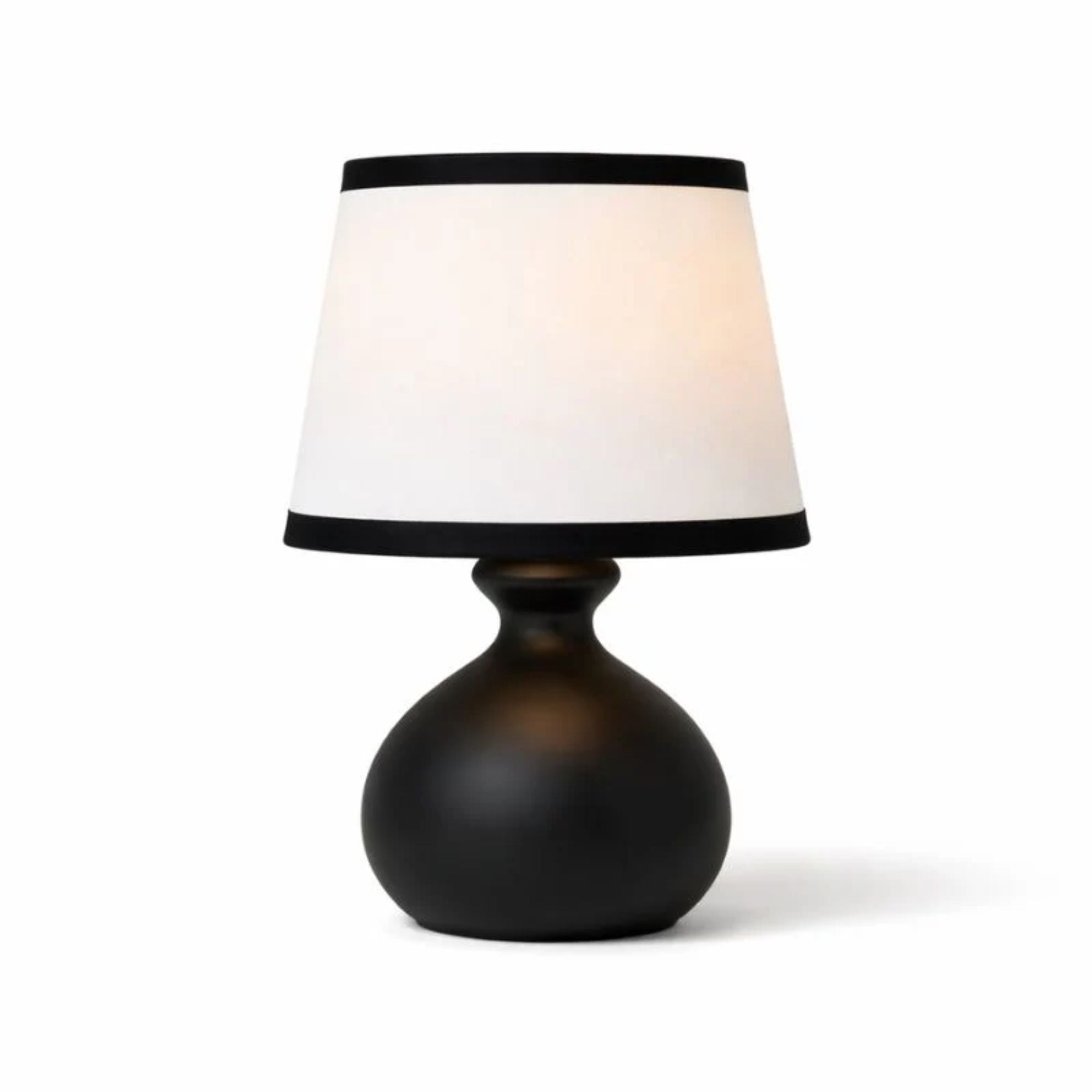 Elegant bordslampa i svart bas med vit lampskärm och kontrastdetaljer i modern klassisk design