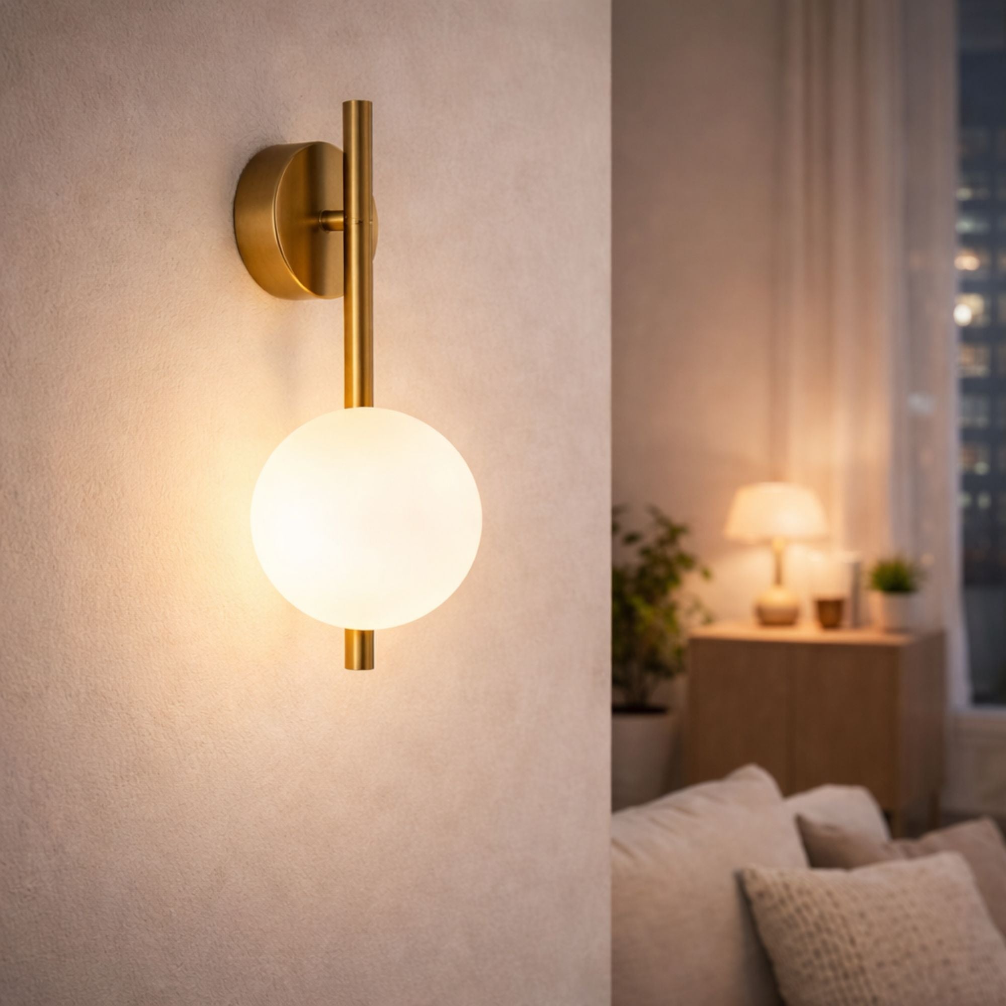 Modern vägglampa i guld med vit glaskupa som lyser i ett mysigt vardagsrum på kvällen med varm stämningsbelysning